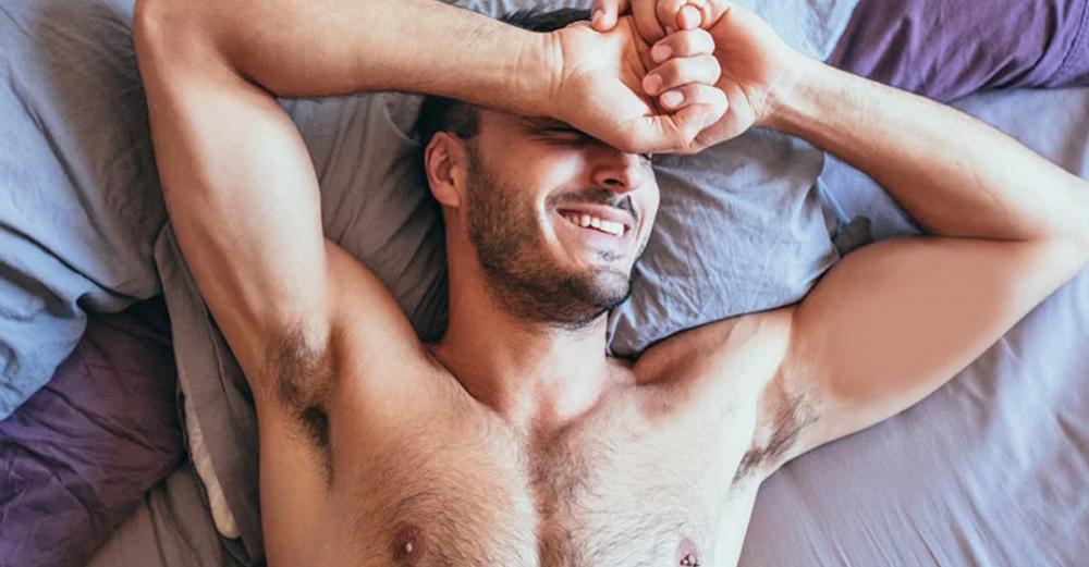 man shirtless in bed